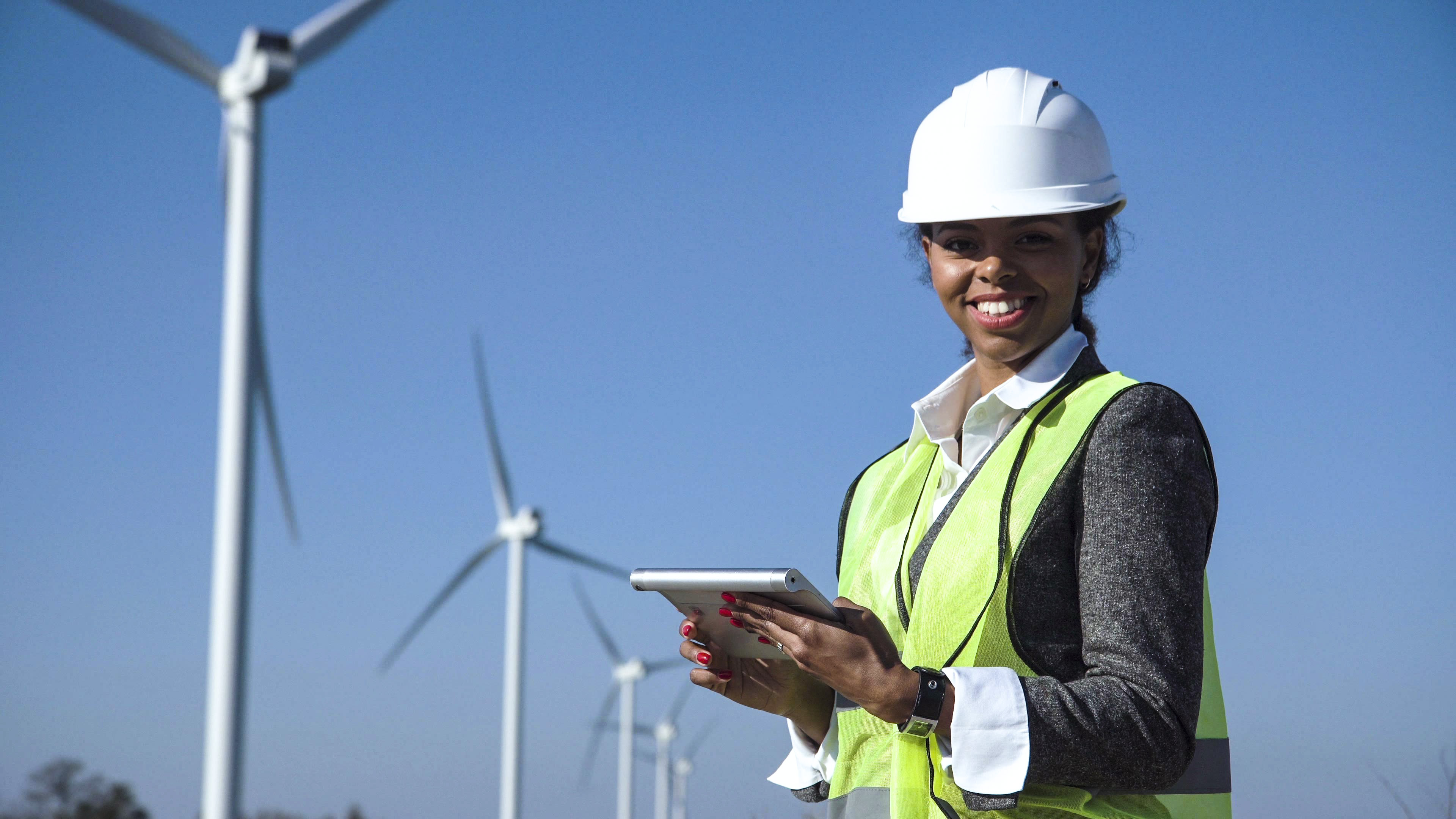 Female engineer in high vis and hardhat on wind farm